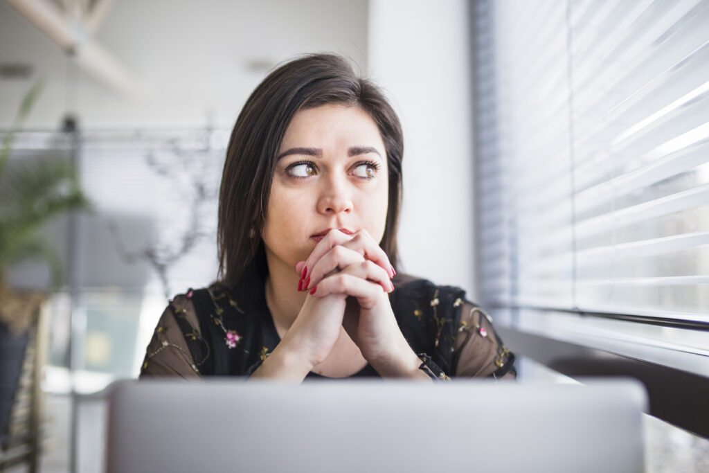 Concerned businesswoman reflecting on data security and privacy in cloud-based HRMS.