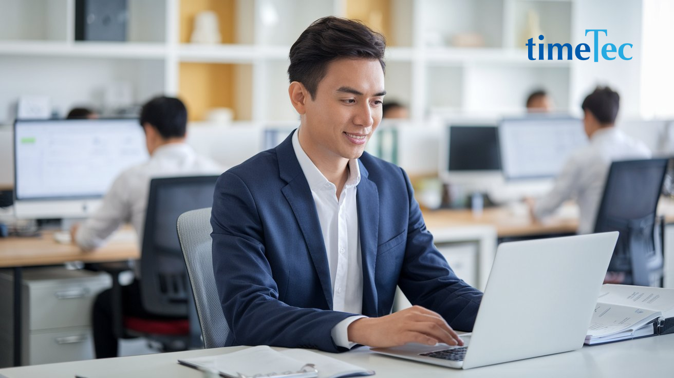 Malaysian employee in a professional office setting using a laptop to streamline claims processes