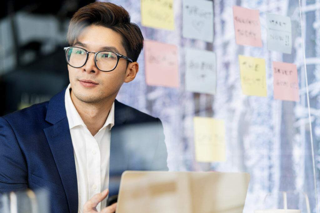 Businessman with smart glasses thinking about payroll management in a collaborative workspace.