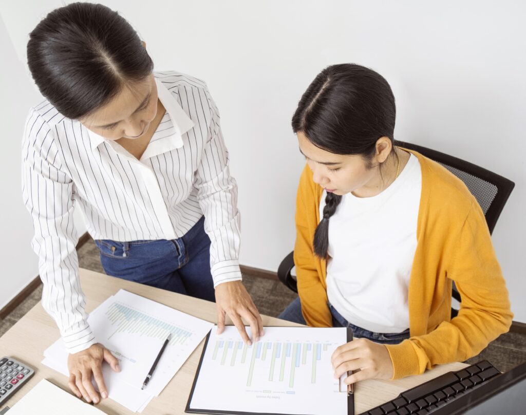 Two women reviewing charts and documents, symbolizing the importance of clarity in claims policies.