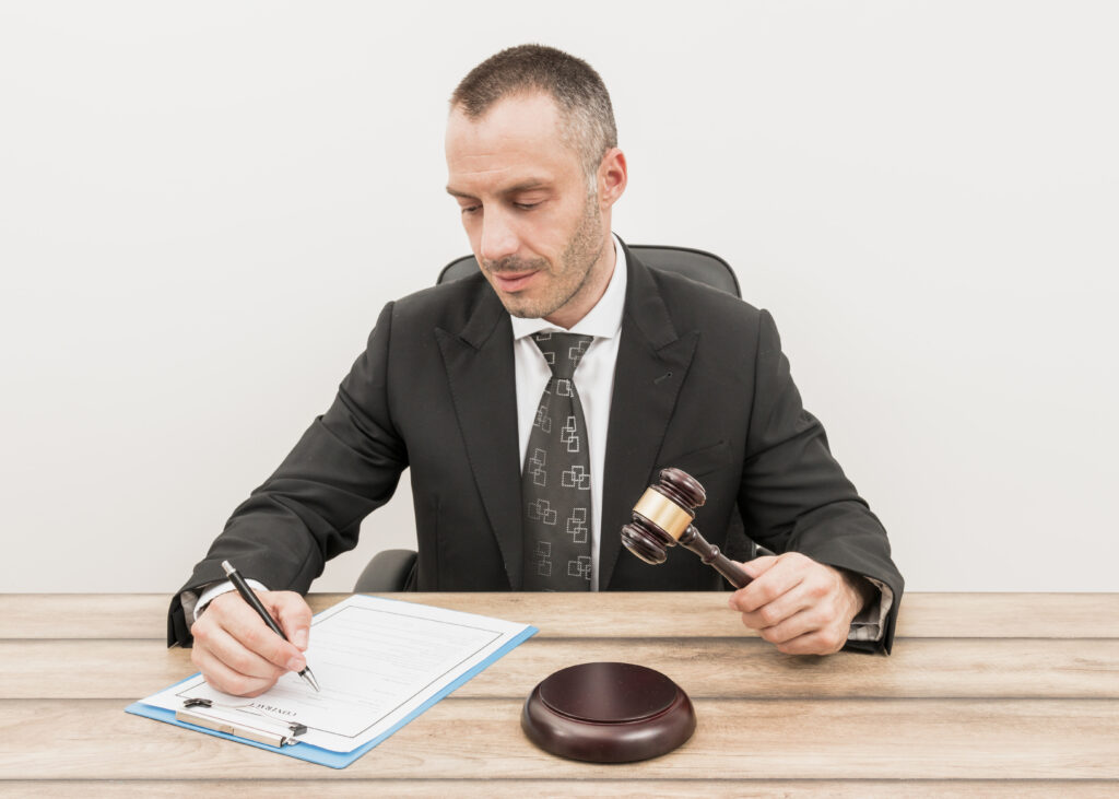 Lawyer filling out a document with a gavel on the desk, symbolizing fairness in employee leave management.