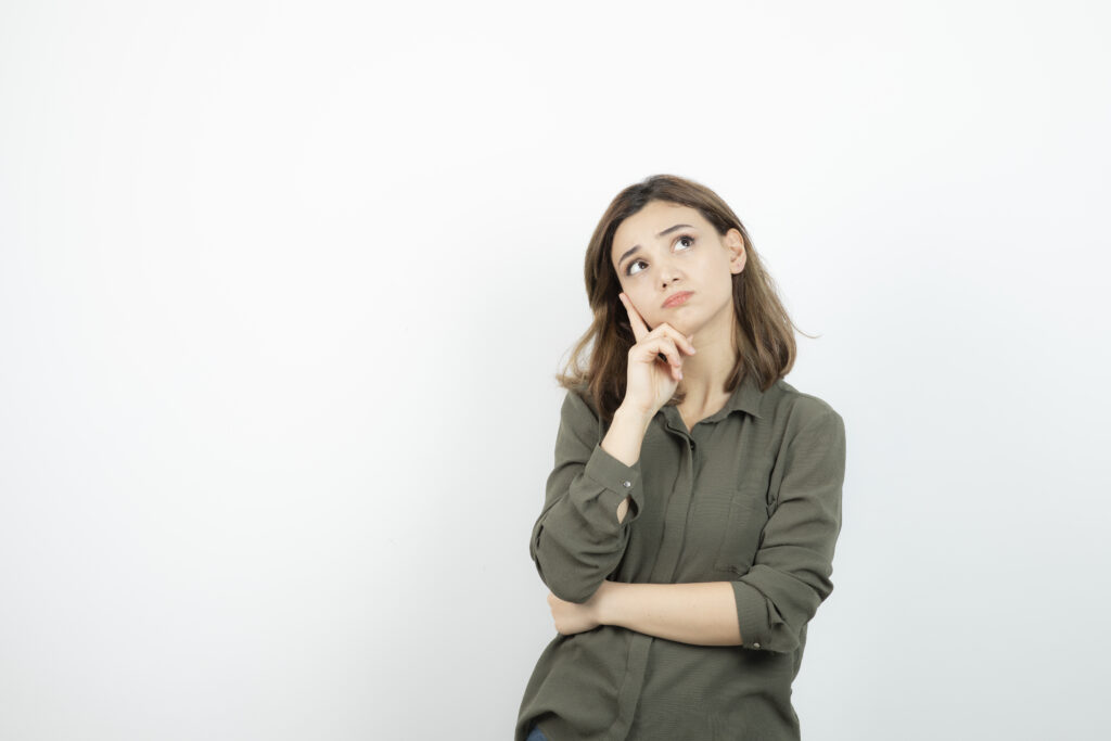 Young woman thinking and contemplating her choices for a digital visitor pass system.