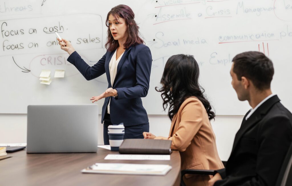 Team leader explaining strategies on a whiteboard to optimize claims management.