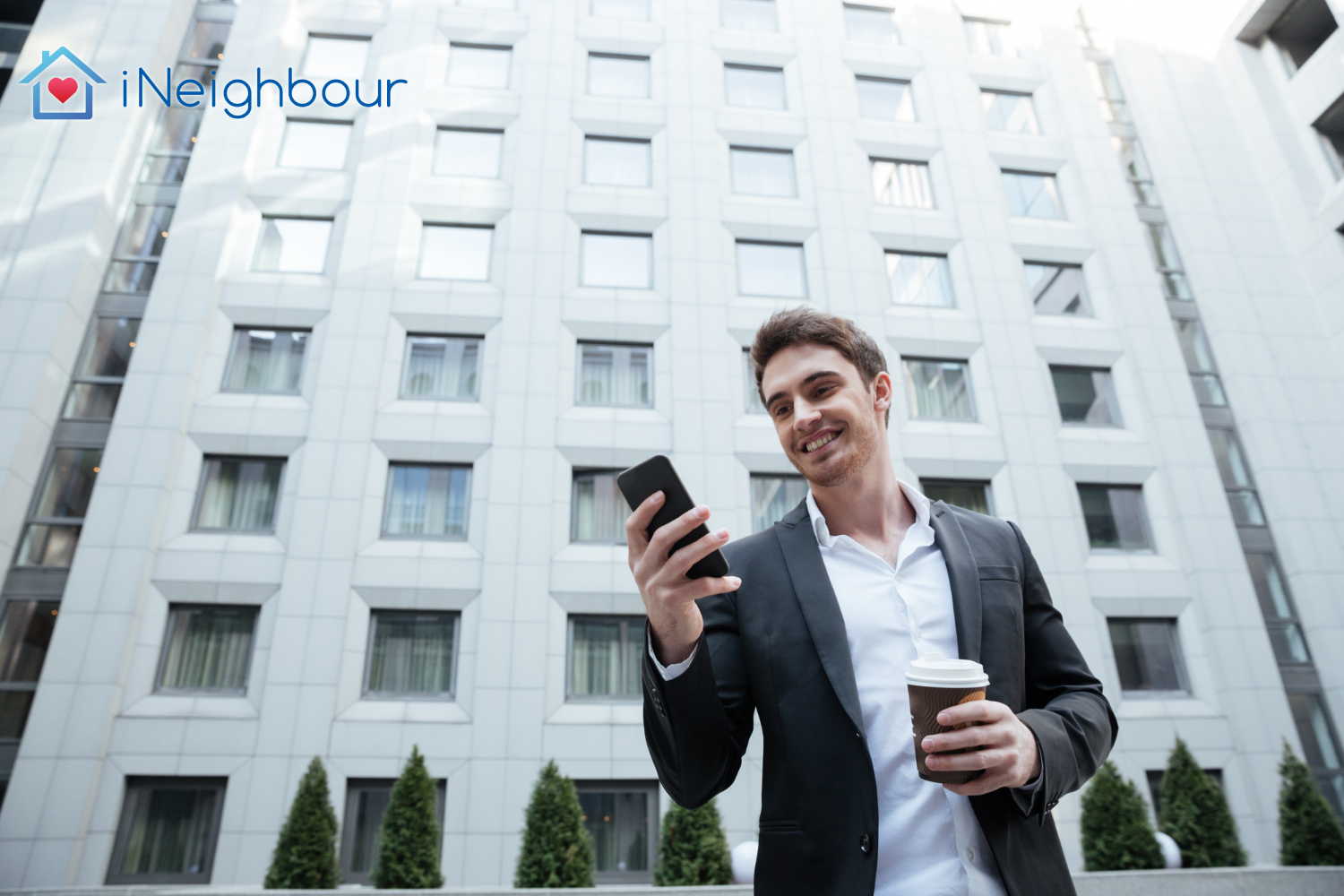 Business professional smiling and using a smartphone in a modern urban setting.