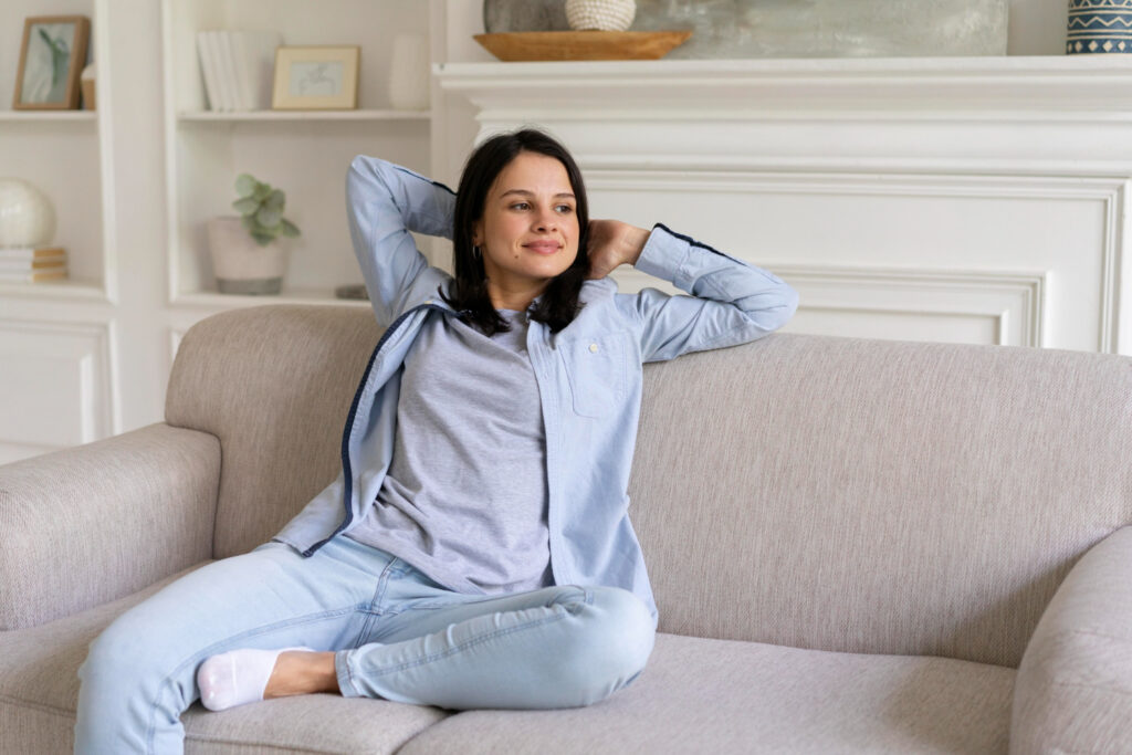 Woman relaxing on a sofa in a secure and peaceful home environment.