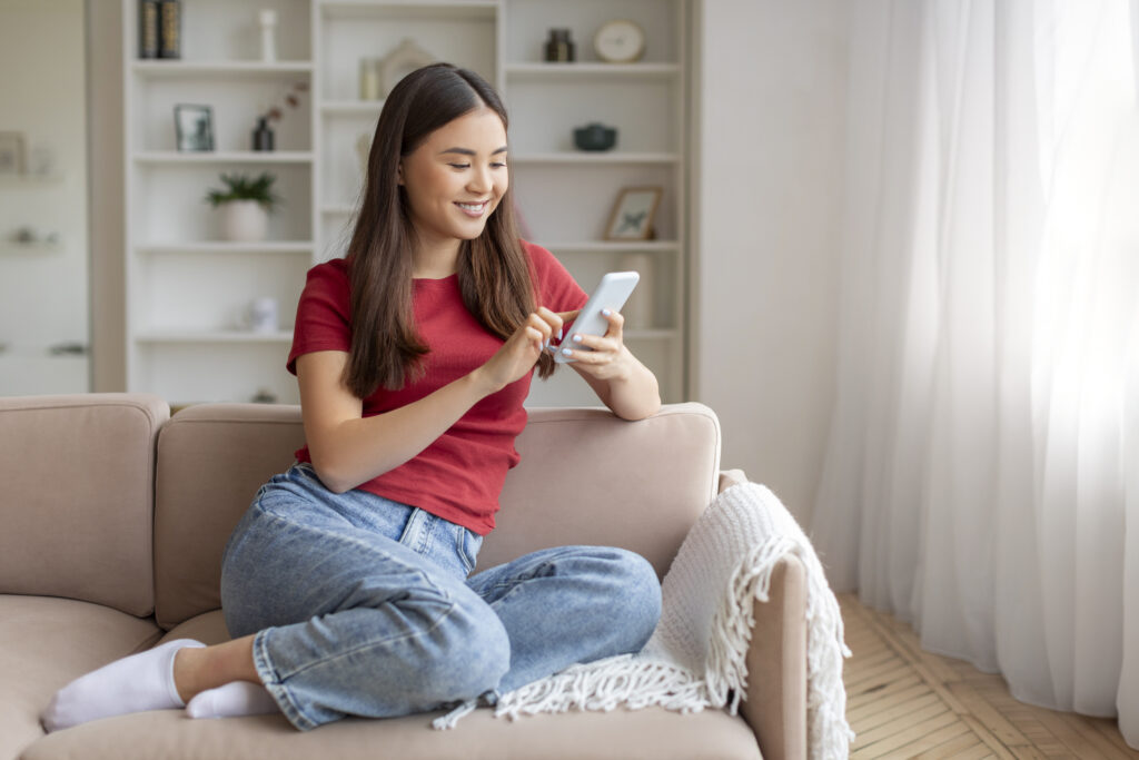 Happy woman using her smartphone to manage bills through Residential E-Billing Solutions.