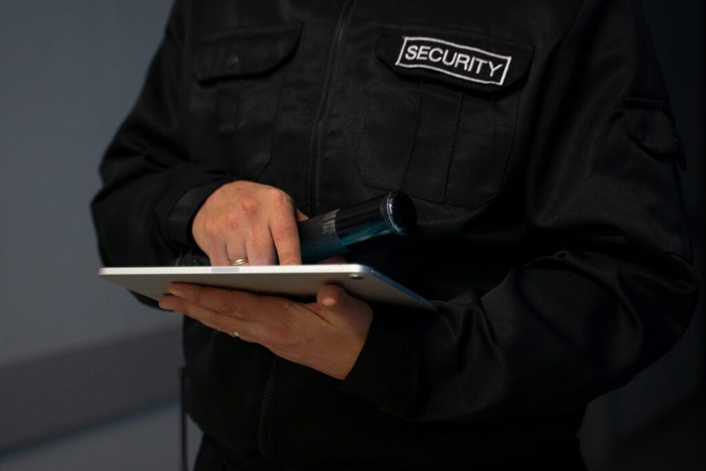 A security guard using a digital system to monitor Blacklist Systems in Residential Areas.