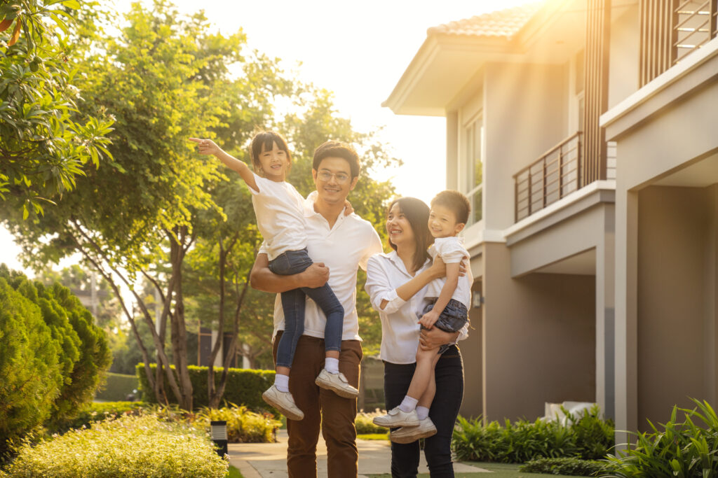 A happy family standing in front of a well-maintained residential property, symbolizing trust in Financial Reporting in Residential Areas.